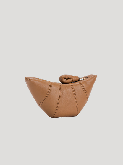 A front view of the croissant-shaped brown leather purse, on a white background.