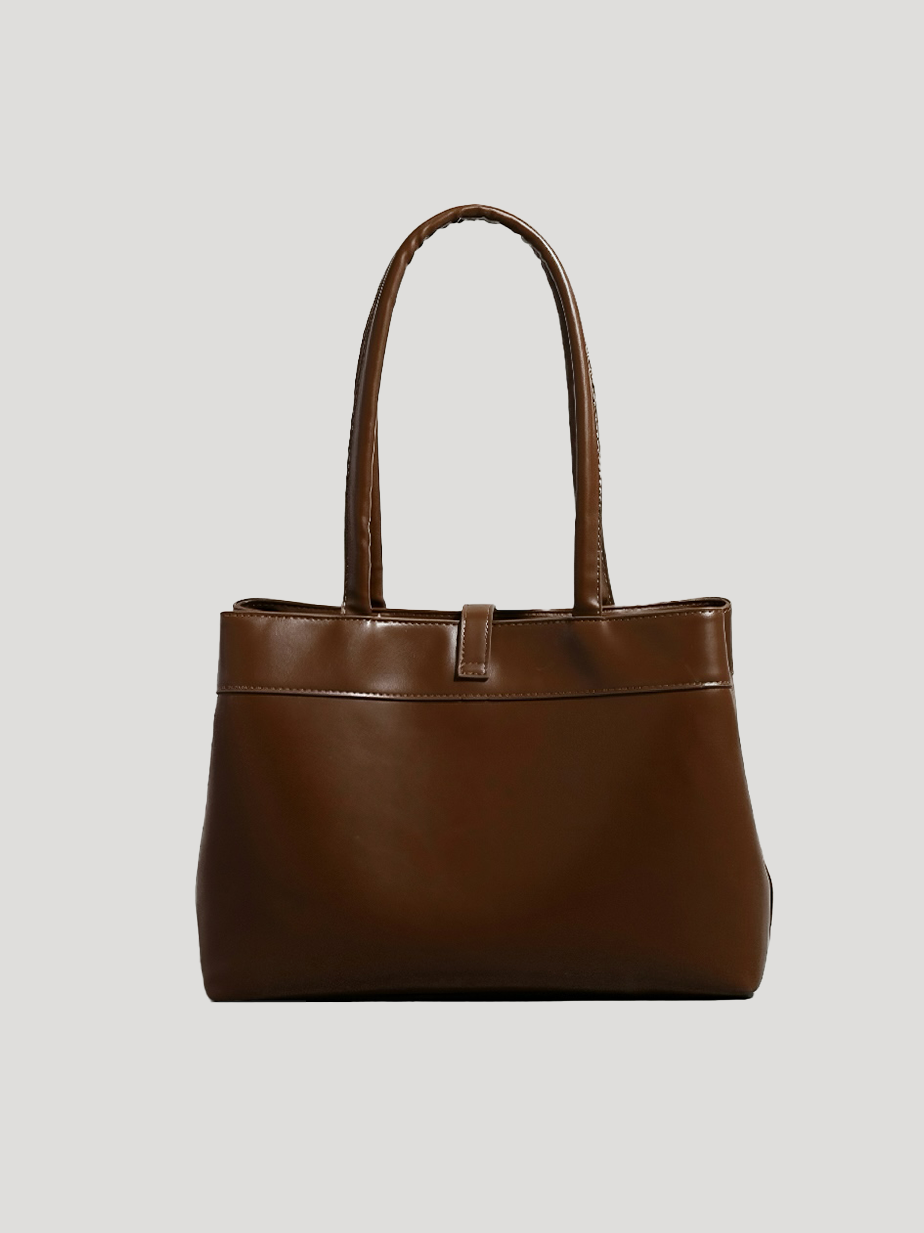 A back view of a brown work tote bag with a spacious top-handle design and a glossy leather texture, set against a white background.