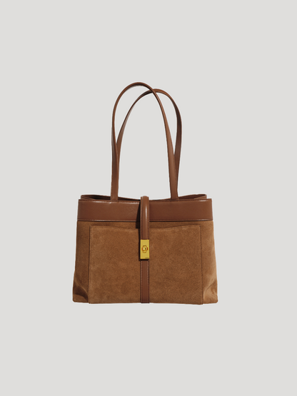 A front view of a brown work tote bag with a spacious top-handle design and a golden metal lock, on a white background.