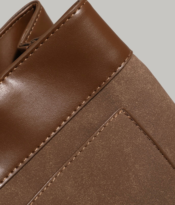 A detailed look at the top edges of a brown work tote bag, featuring fine stitching craftsmanship and high-quality leather.