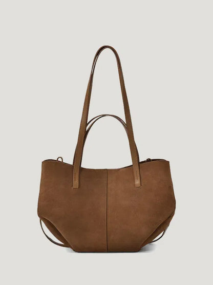 A brown hand/shoulder Polene bag, featuring high-quality suede leather and catfish whiskers, set against a white background.