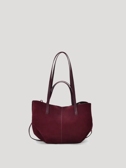 A red wine hand/shoulder Polene bag, featuring high-quality suede leather and catfish whiskers, set against a white background.